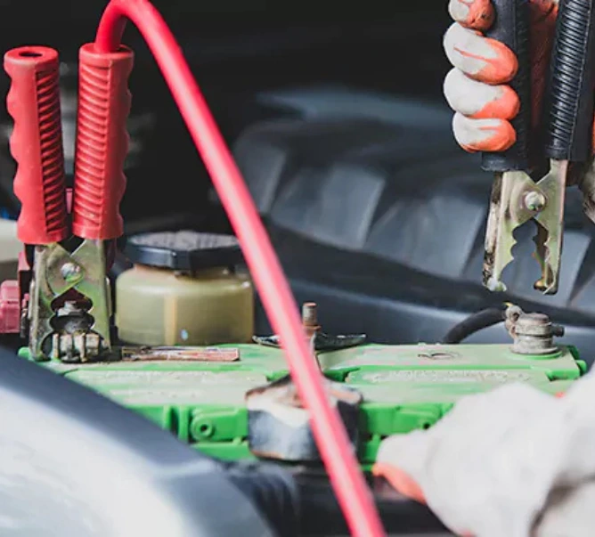 Truck battery jump start using jumper cables during roadside repair service